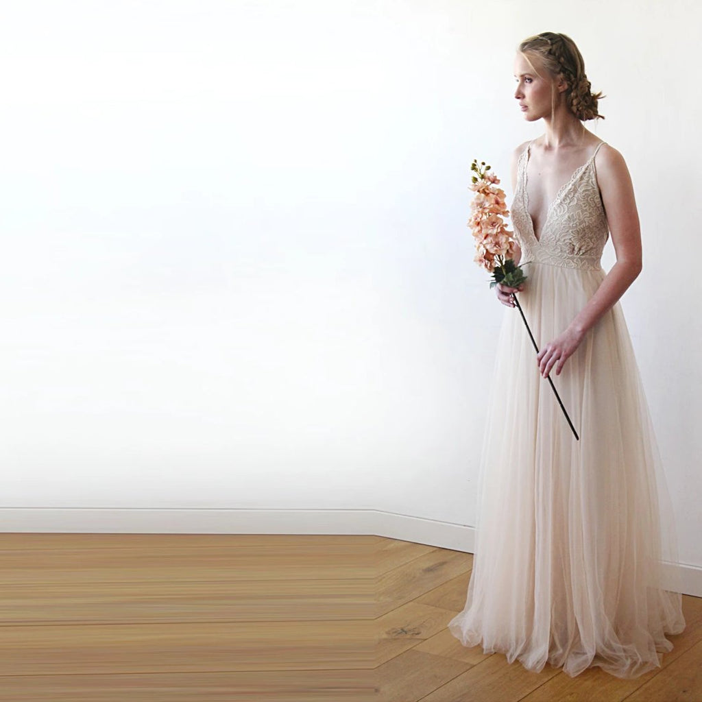 Three quarter front view of the Champagne Lace and Tulle Wedding dress ,showing  the lace bodice, sphaghetti straps and the flowing floor -length skirt.