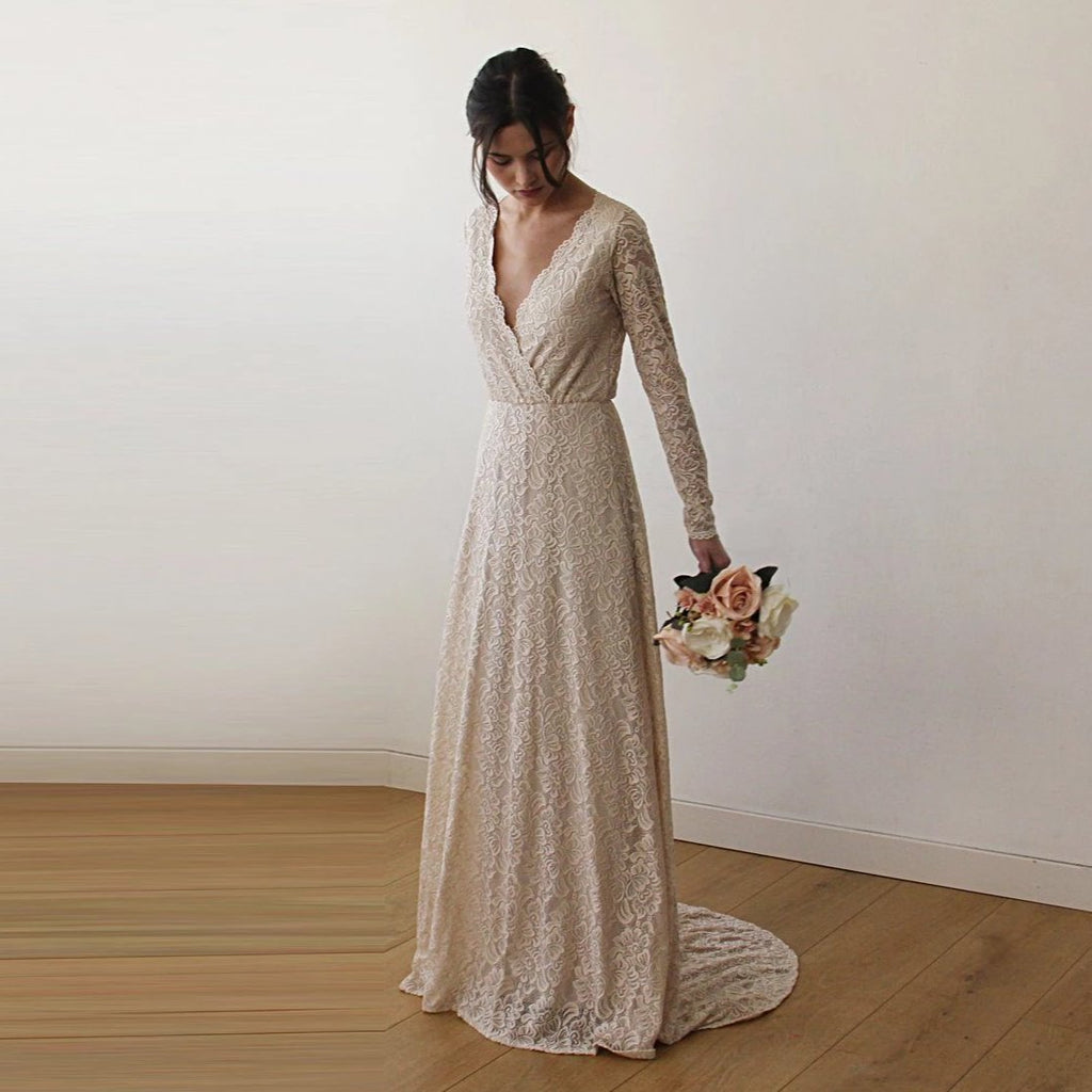 Front-view of bride wearing a deep v-neck champagne wrap lace wedding gown with train - intimate bridal portrait.portrait