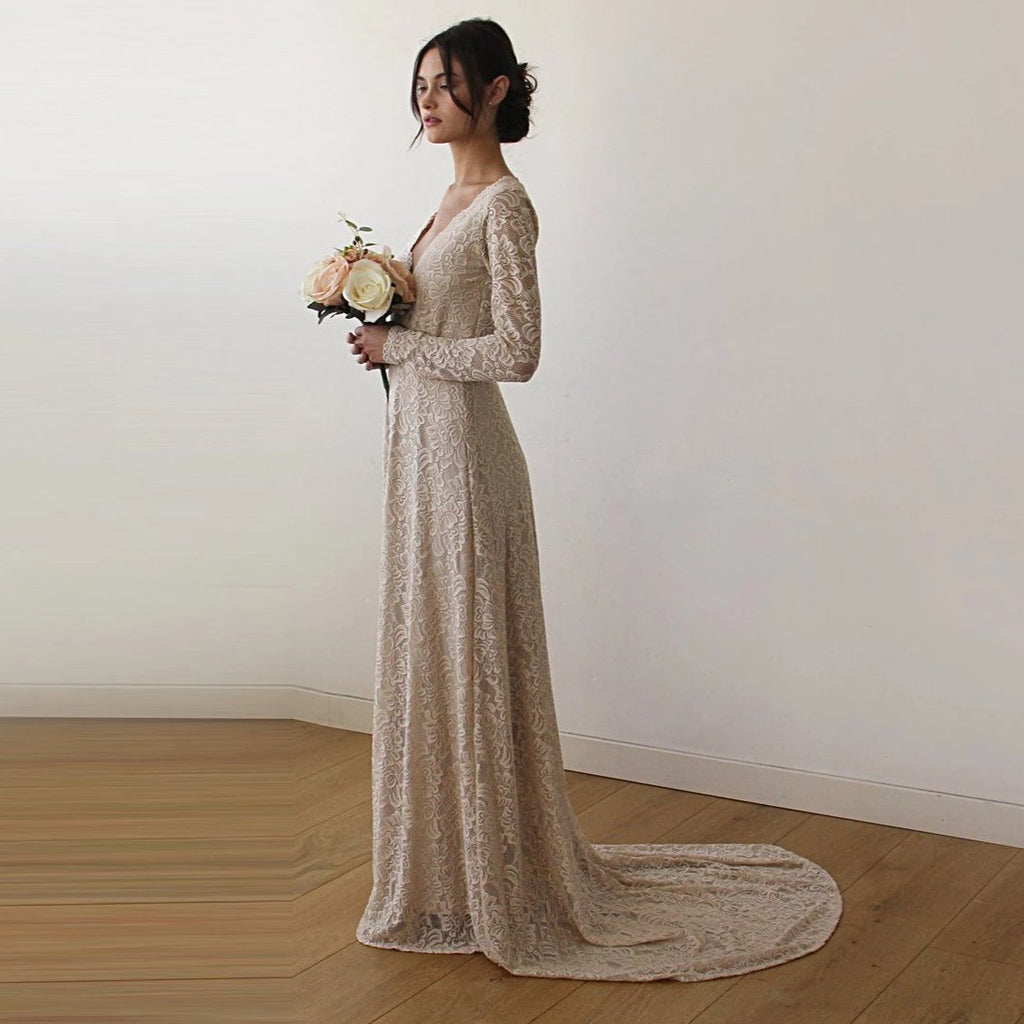 Left-sideview of bride with a champagne wrap lace wedding gown  with long sleeves and train- full length bridal portrait.