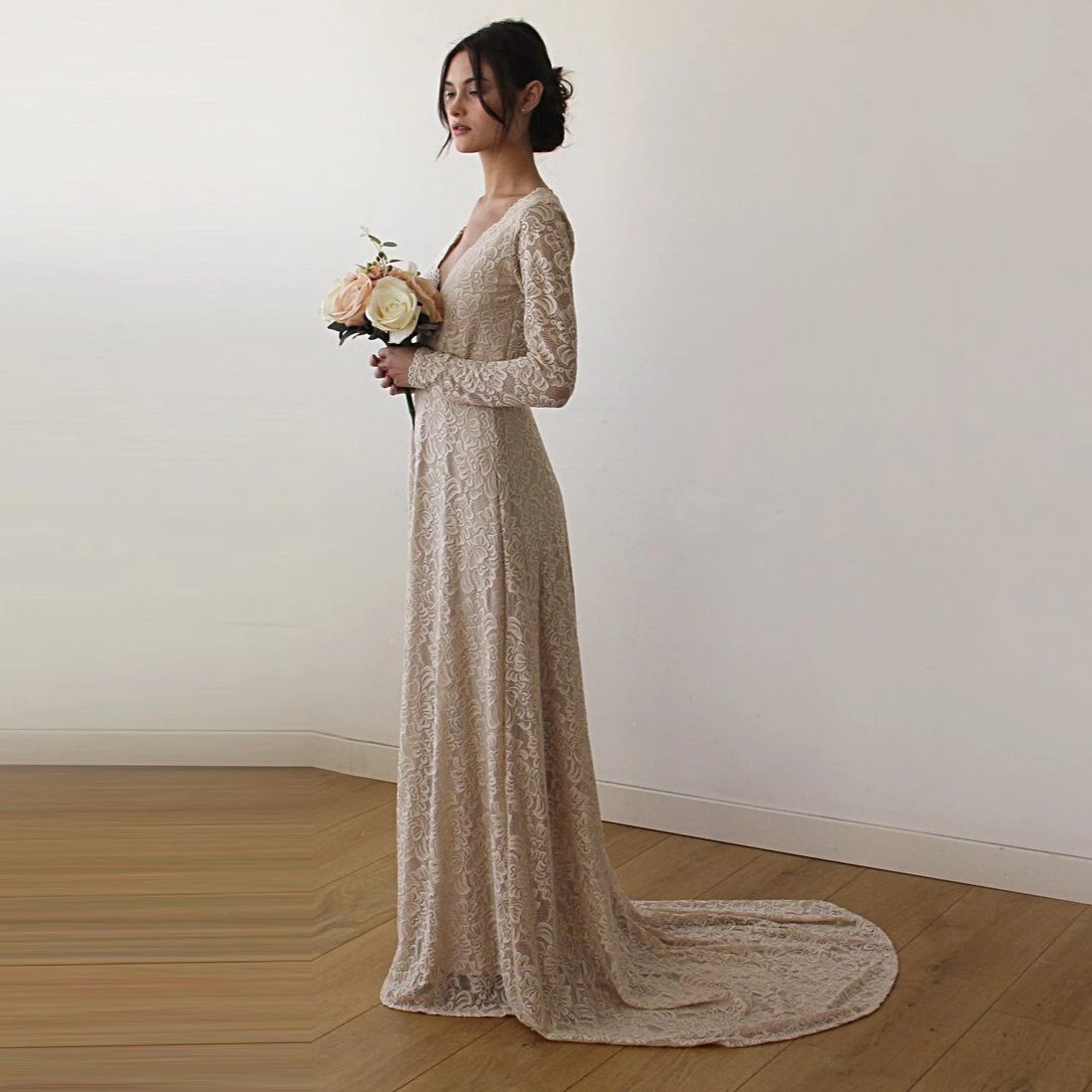 Left-sideview of bride with a champagne wrap lace wedding gown  with long sleeves and train- full length bridal portrait.