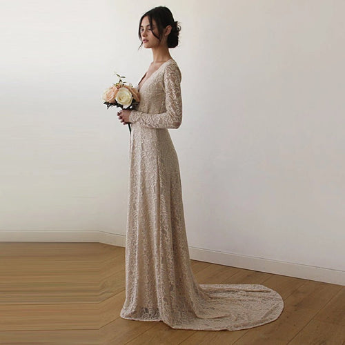 Left-sideview of bride with a champagne wrap lace wedding gown  with long sleeves and train- full length bridal portrait.