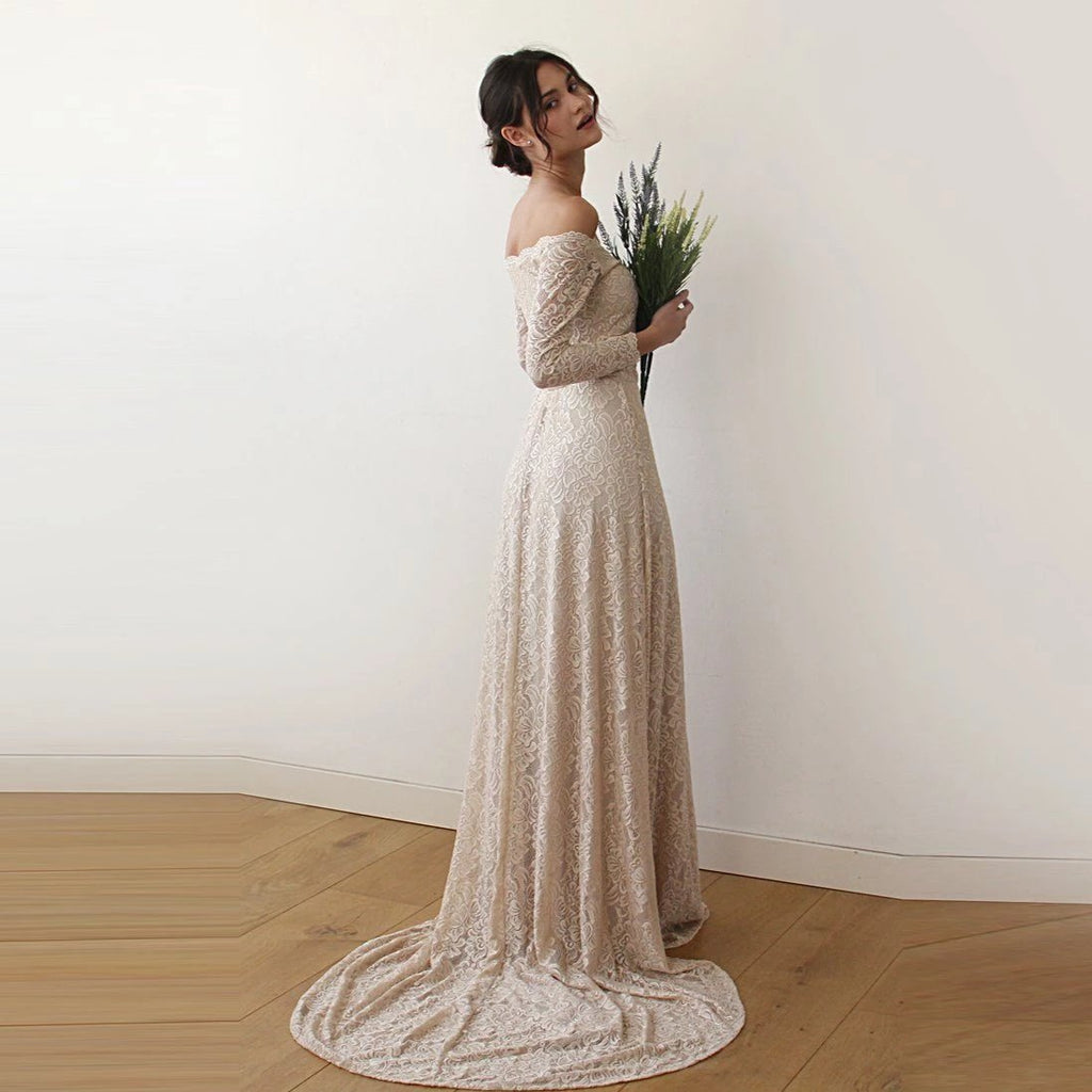 Right side view of model wearing a champagne off-shoulder lace wedding gown with long sleeves, fitted silhouette, and trailing train.